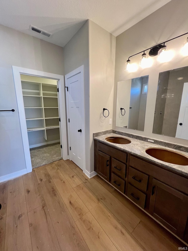 bathroom featuring vanity, wood-type flooring, and a textured ceiling