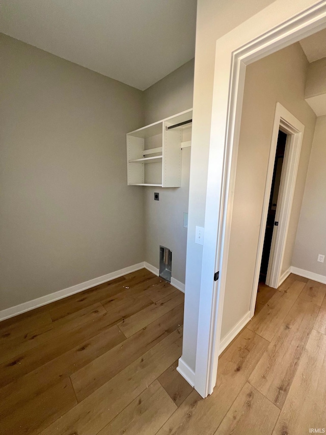 clothes washing area with light hardwood / wood-style flooring and electric dryer hookup