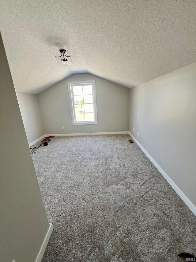 bonus room featuring carpet flooring, a textured ceiling, and lofted ceiling