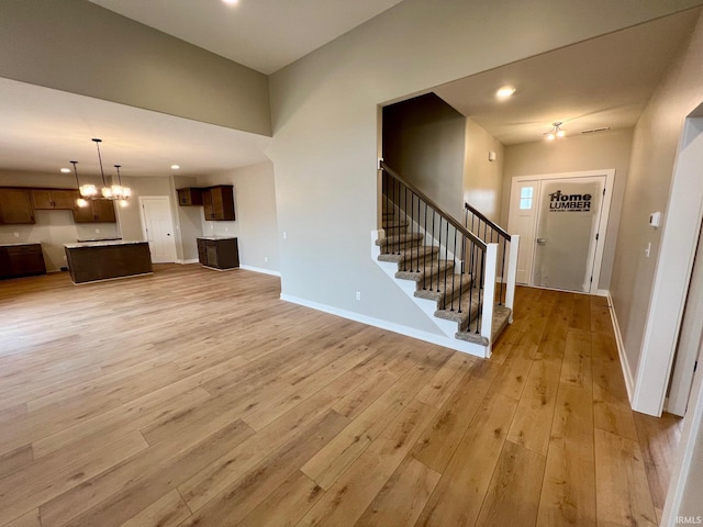 unfurnished living room featuring light hardwood / wood-style flooring and a notable chandelier