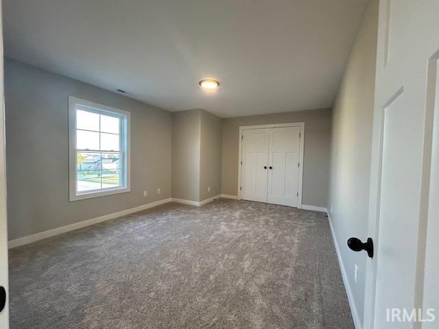 unfurnished bedroom with carpet floors and a closet