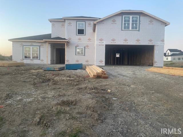 back house at dusk featuring a garage