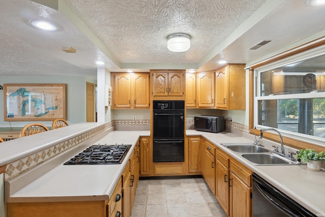 kitchen with sink, black appliances, kitchen peninsula, and a textured ceiling