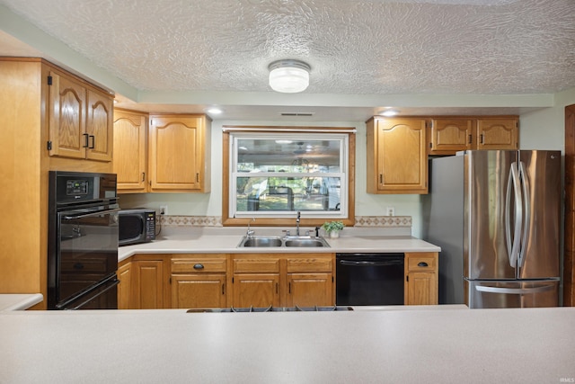 kitchen with sink, black appliances, and a textured ceiling