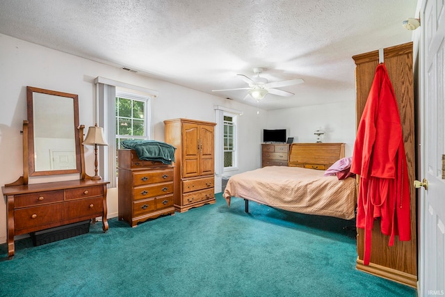 bedroom with ceiling fan, a textured ceiling, and carpet flooring