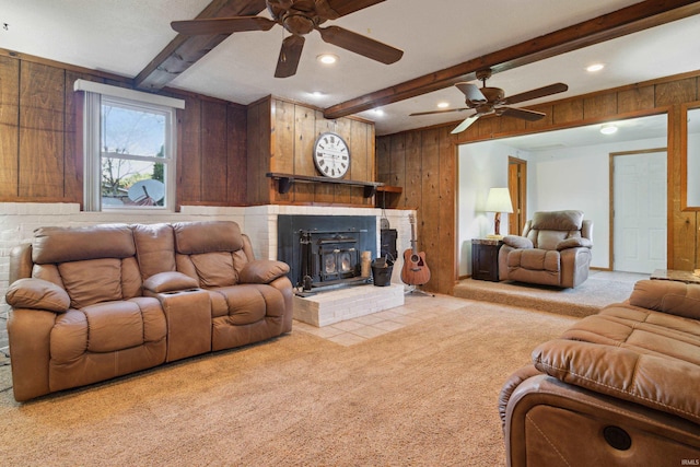 carpeted living room featuring beamed ceiling, a wood stove, and wood walls