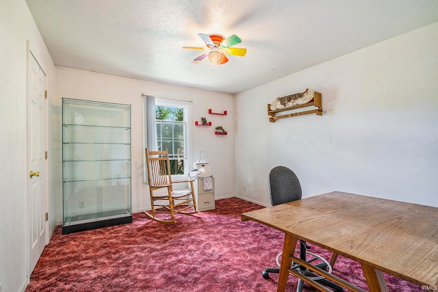 carpeted office space featuring ceiling fan and a textured ceiling