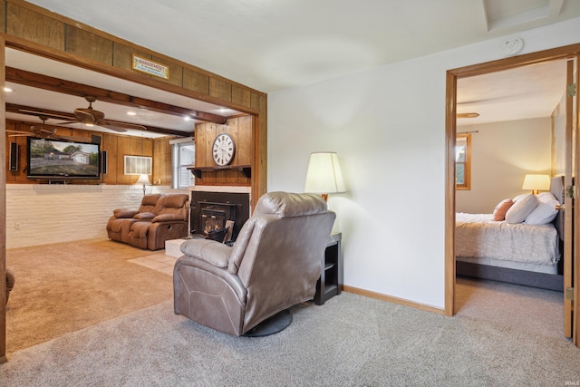 living room featuring ceiling fan, wooden walls, light colored carpet, and beamed ceiling