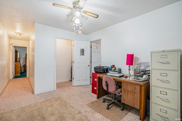 carpeted office space featuring ceiling fan and a textured ceiling