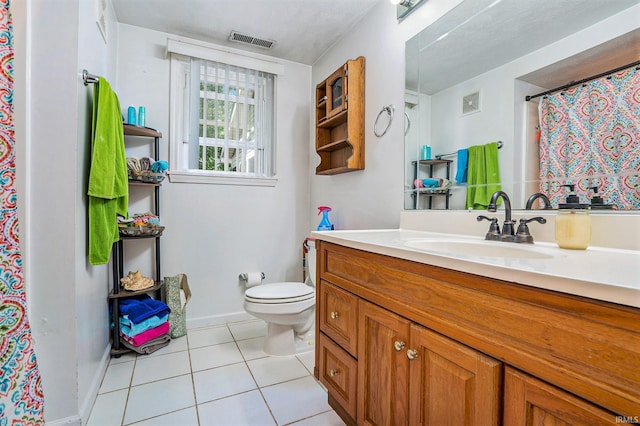 bathroom with tile patterned flooring, vanity, and toilet