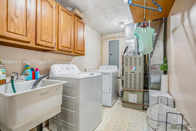 laundry area featuring cabinets, a textured ceiling, electric panel, sink, and separate washer and dryer