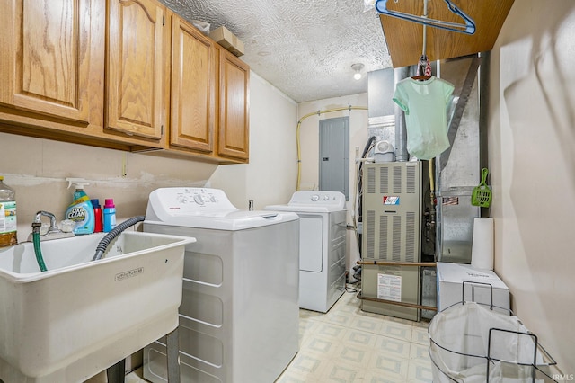 washroom featuring cabinets, sink, washing machine and clothes dryer, and a textured ceiling