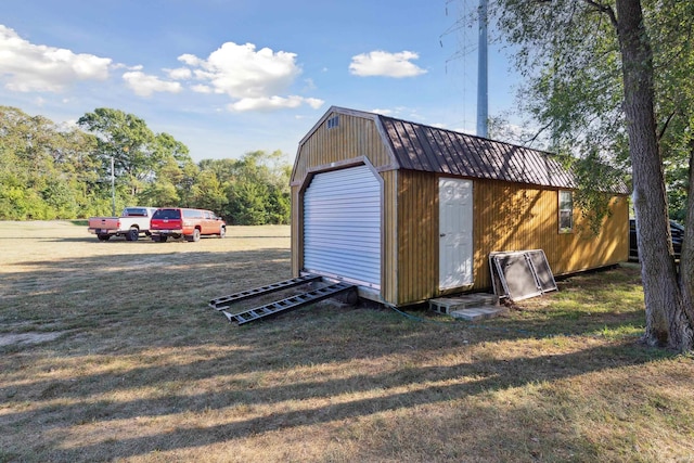 view of outdoor structure with a garage and a lawn