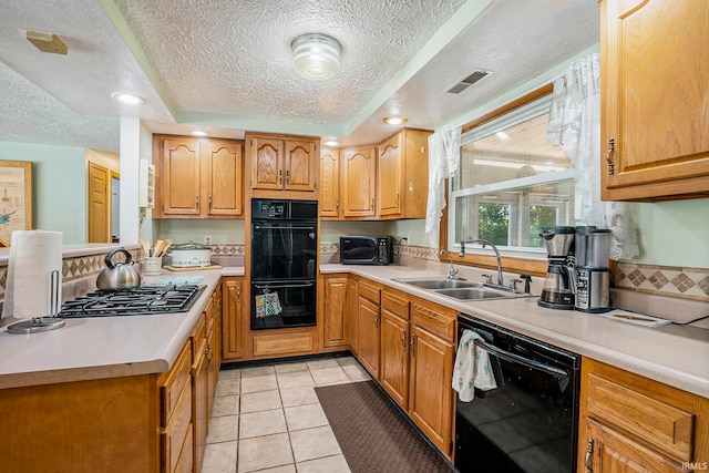 kitchen with a textured ceiling, black appliances, sink, and light tile patterned floors