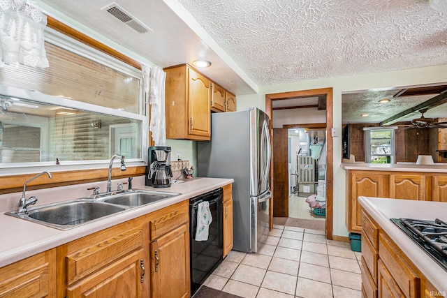 kitchen featuring light tile patterned floors, a textured ceiling, sink, and black appliances