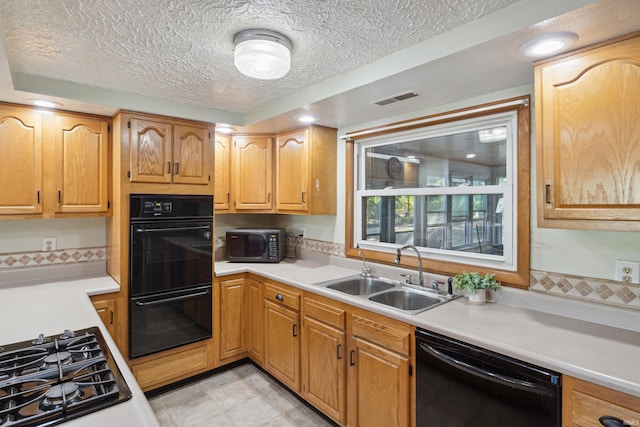 kitchen with sink, black appliances, and a textured ceiling