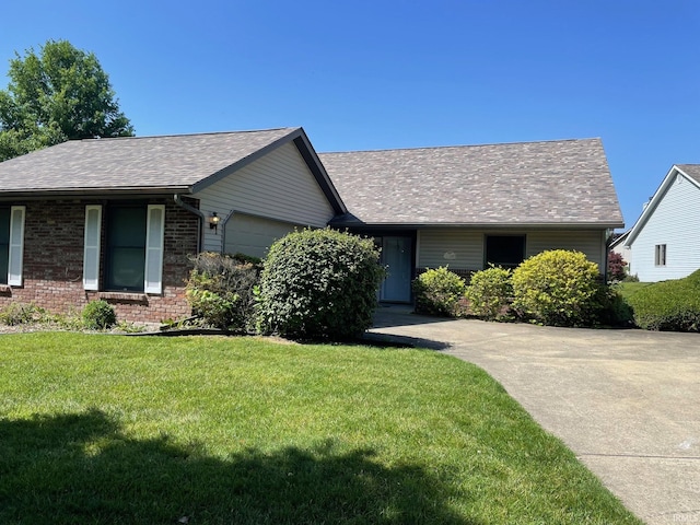 ranch-style home with a garage, a shingled roof, a front lawn, and brick siding