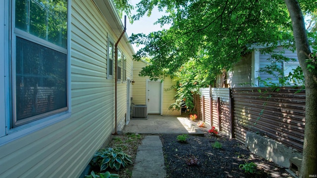 view of side of home with a patio area and central air condition unit