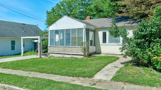 bungalow-style home featuring a sunroom and a front yard