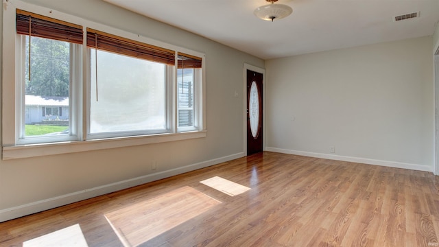 unfurnished room with a healthy amount of sunlight and light hardwood / wood-style flooring