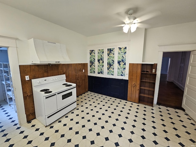 kitchen featuring wooden walls, white electric range oven, ceiling fan, and extractor fan