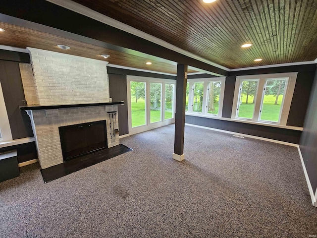 unfurnished living room with crown molding, a large fireplace, wood ceiling, and dark colored carpet