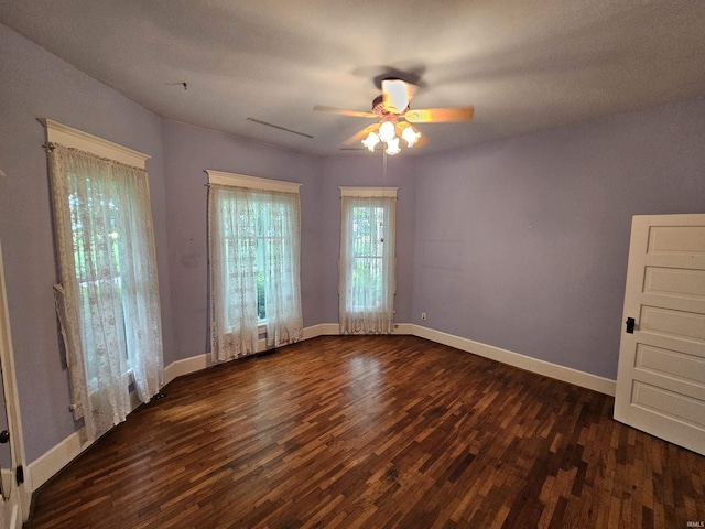 unfurnished room with ceiling fan and dark wood-type flooring