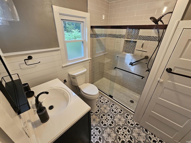 bathroom with tile patterned floors, vanity, toilet, and a shower with shower door