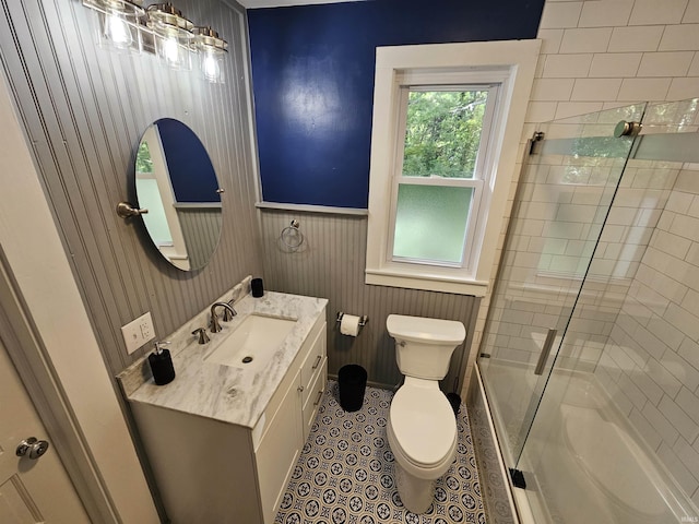 full bathroom with tile patterned flooring, toilet, combined bath / shower with glass door, and vanity