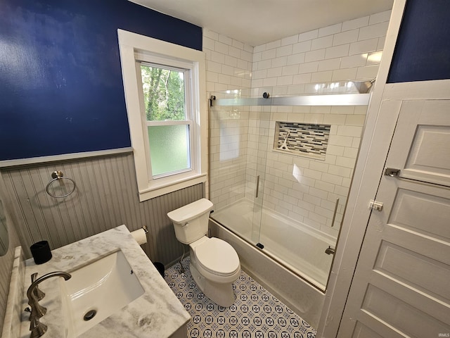 full bathroom featuring tile patterned floors, toilet, vanity, and combined bath / shower with glass door