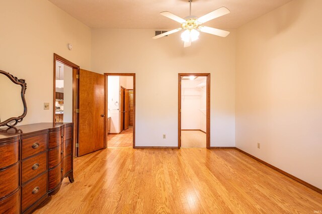 unfurnished bedroom with ceiling fan, vaulted ceiling, and light wood-type flooring