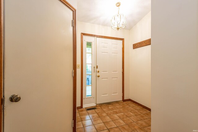 kitchen featuring stainless steel appliances, wall chimney range hood, and light tile floors