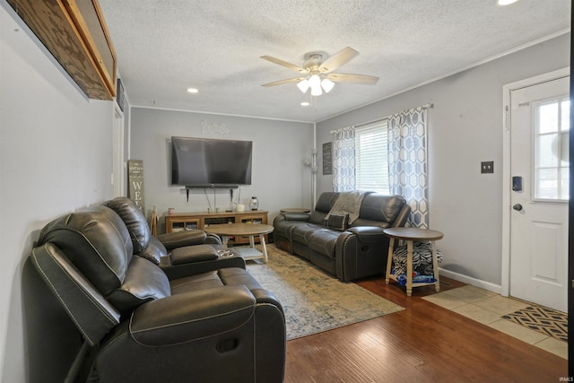 living room with ceiling fan, wood-type flooring, a textured ceiling, and a wealth of natural light