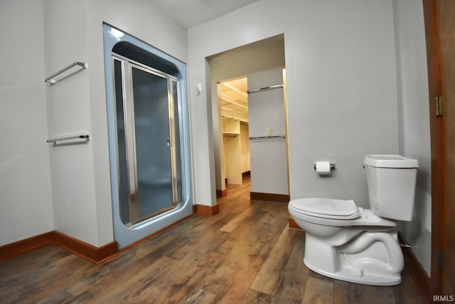 bathroom featuring hardwood / wood-style flooring, toilet, and an enclosed shower