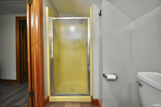 bathroom with lofted ceiling, toilet, an enclosed shower, and hardwood / wood-style flooring