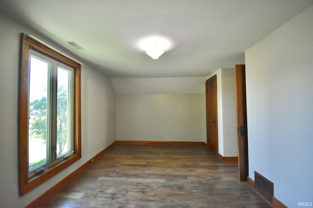 bonus room with dark hardwood / wood-style flooring and vaulted ceiling