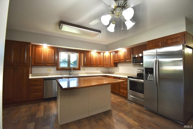 kitchen with ceiling fan, a center island, dark hardwood / wood-style floors, and appliances with stainless steel finishes