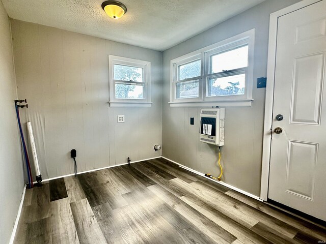 washroom with hardwood / wood-style floors, a textured ceiling, and heating unit