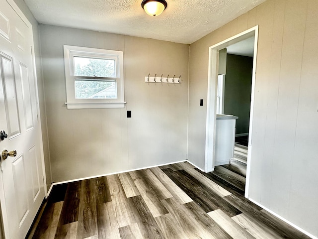 empty room with hardwood / wood-style floors and a textured ceiling