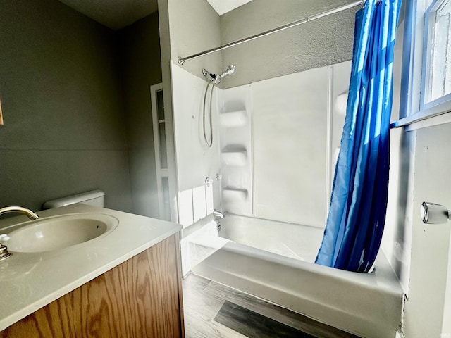 full bathroom featuring wood-type flooring, vanity, shower / tub combo, and toilet