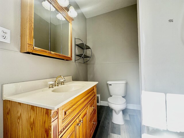 bathroom featuring vanity, wood-type flooring, and toilet