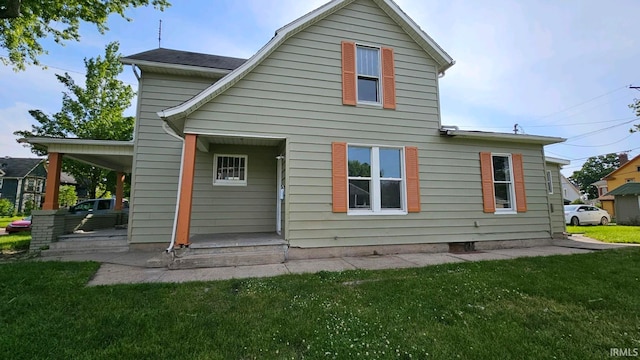 rear view of property featuring a lawn