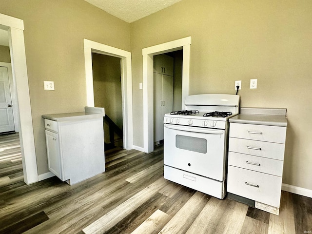 kitchen featuring white cabinets, dark hardwood / wood-style flooring, and gas range gas stove