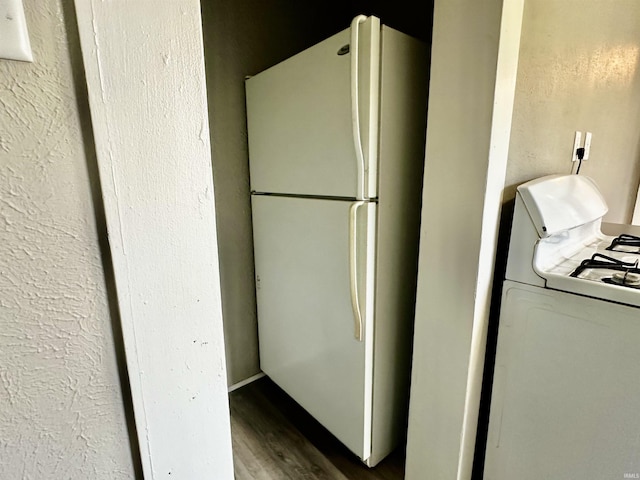 kitchen with wood-type flooring, white appliances, and washer / clothes dryer