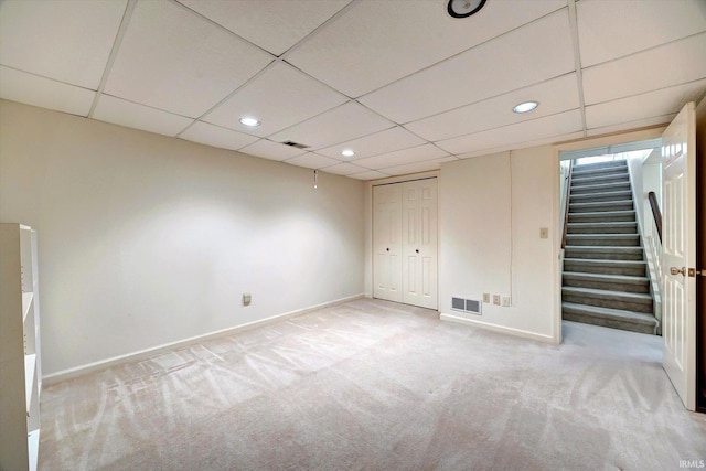 finished basement featuring stairs, light carpet, visible vents, and baseboards