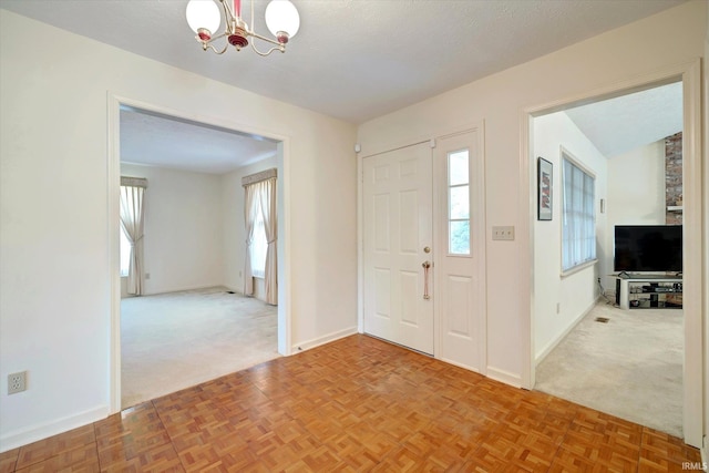 foyer entrance featuring carpet floors, a wealth of natural light, and a chandelier