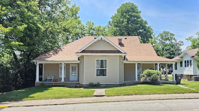 bungalow-style house featuring a porch, central air condition unit, and a front yard