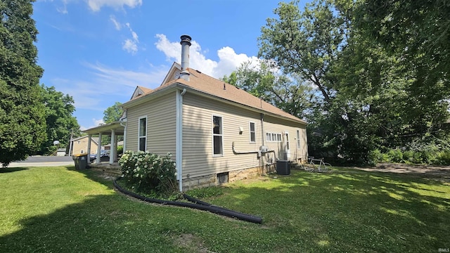 view of side of property featuring a yard and central air condition unit