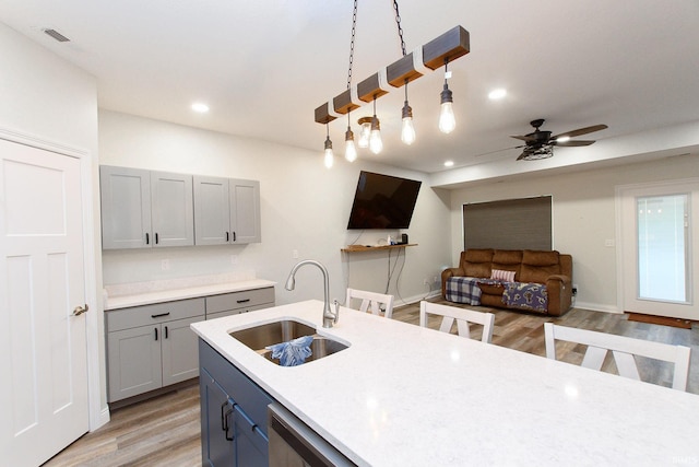 kitchen with ceiling fan, sink, light hardwood / wood-style flooring, decorative light fixtures, and gray cabinets