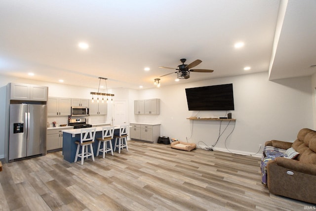 living room with ceiling fan and light hardwood / wood-style floors